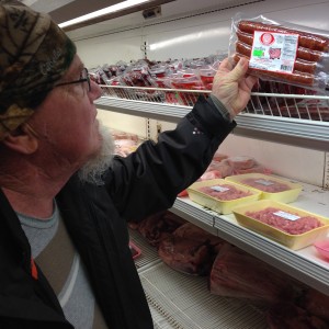 Pastrami inspects a package of pork sausage